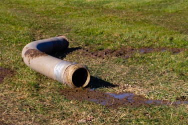 Big pipe with slurry, lying on grass